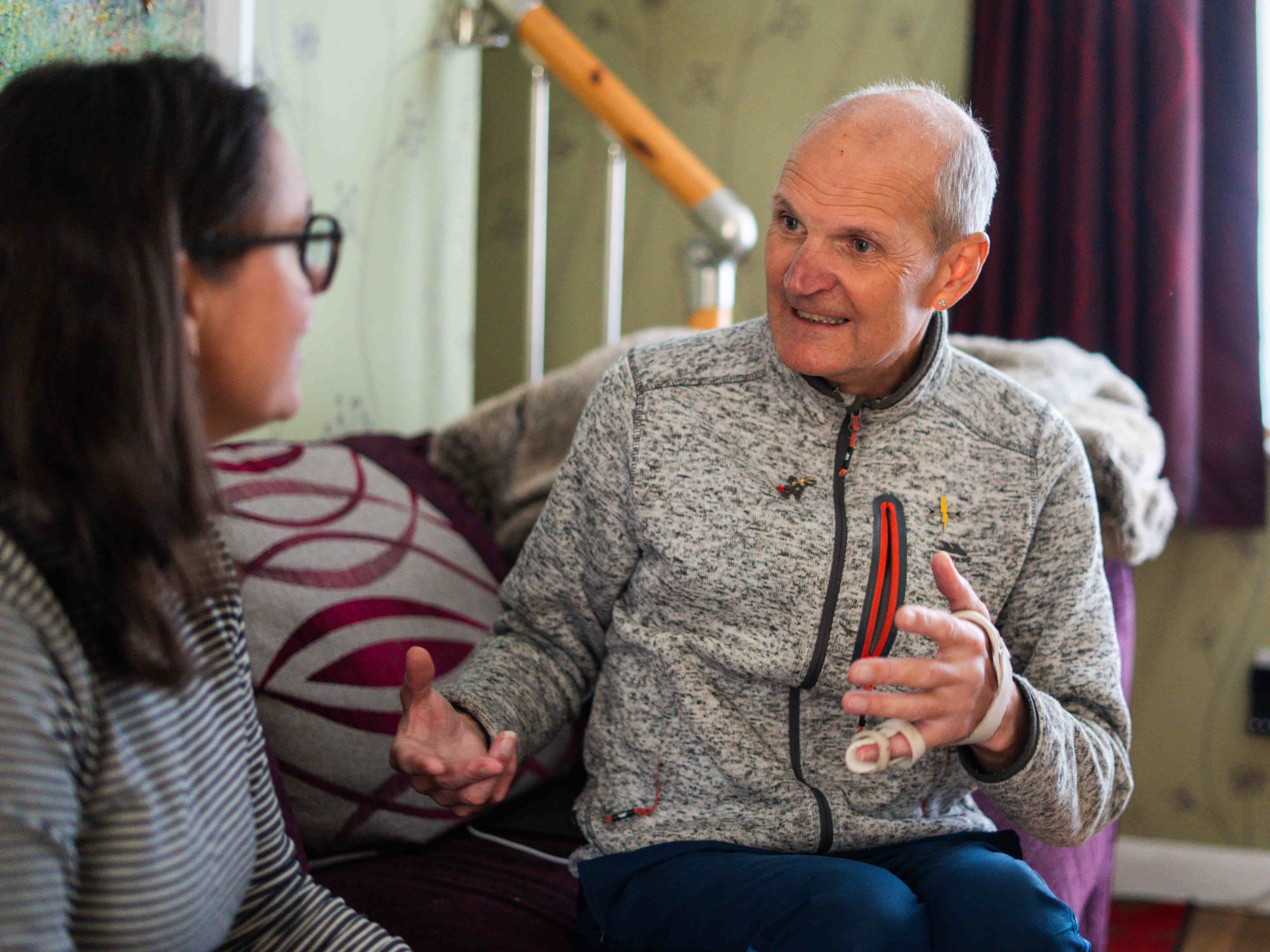 a man and a woman seating on the couch and talking to each other