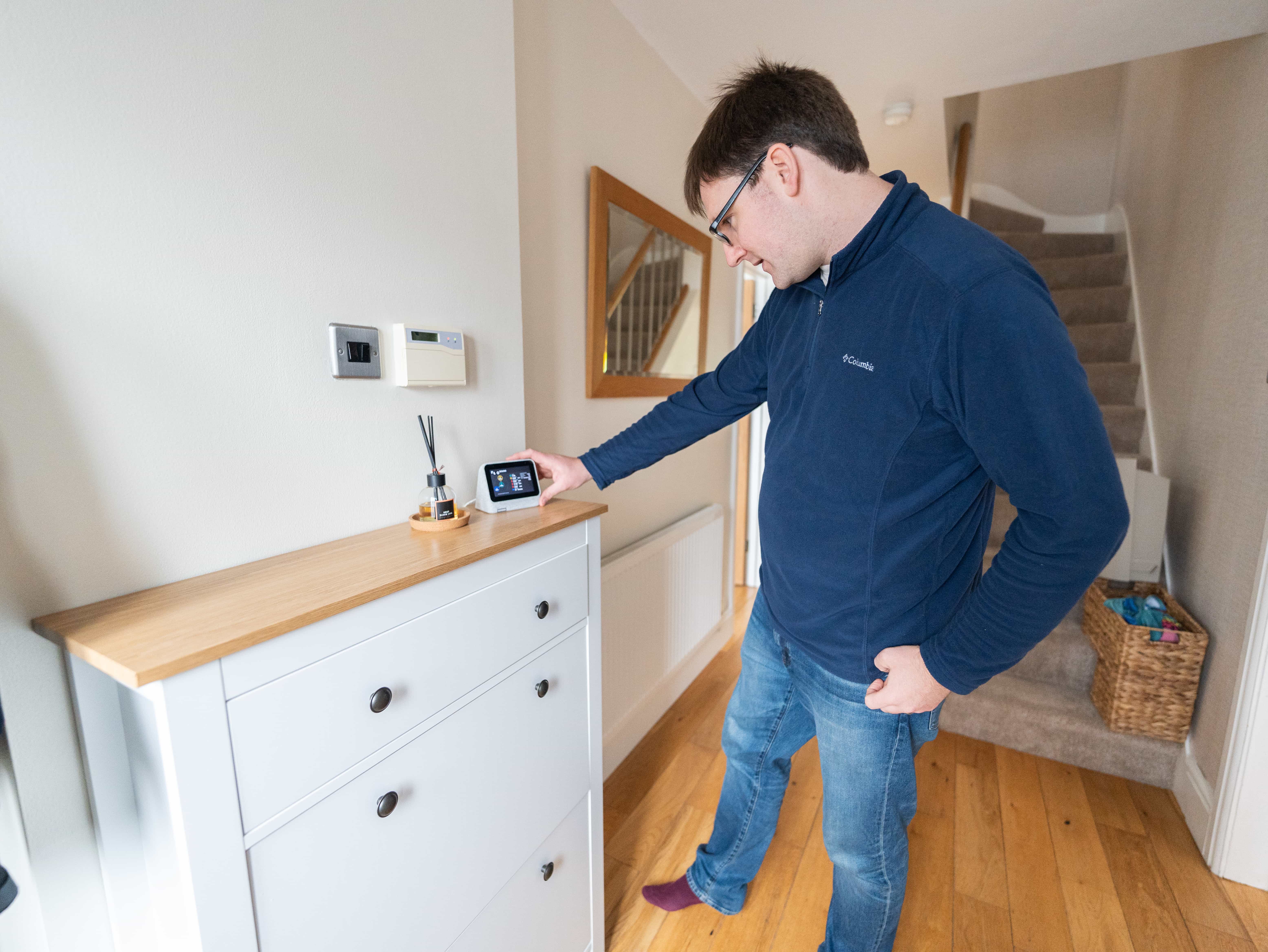 a man standing in front of a drawer, holding an energy device that sits on its surface