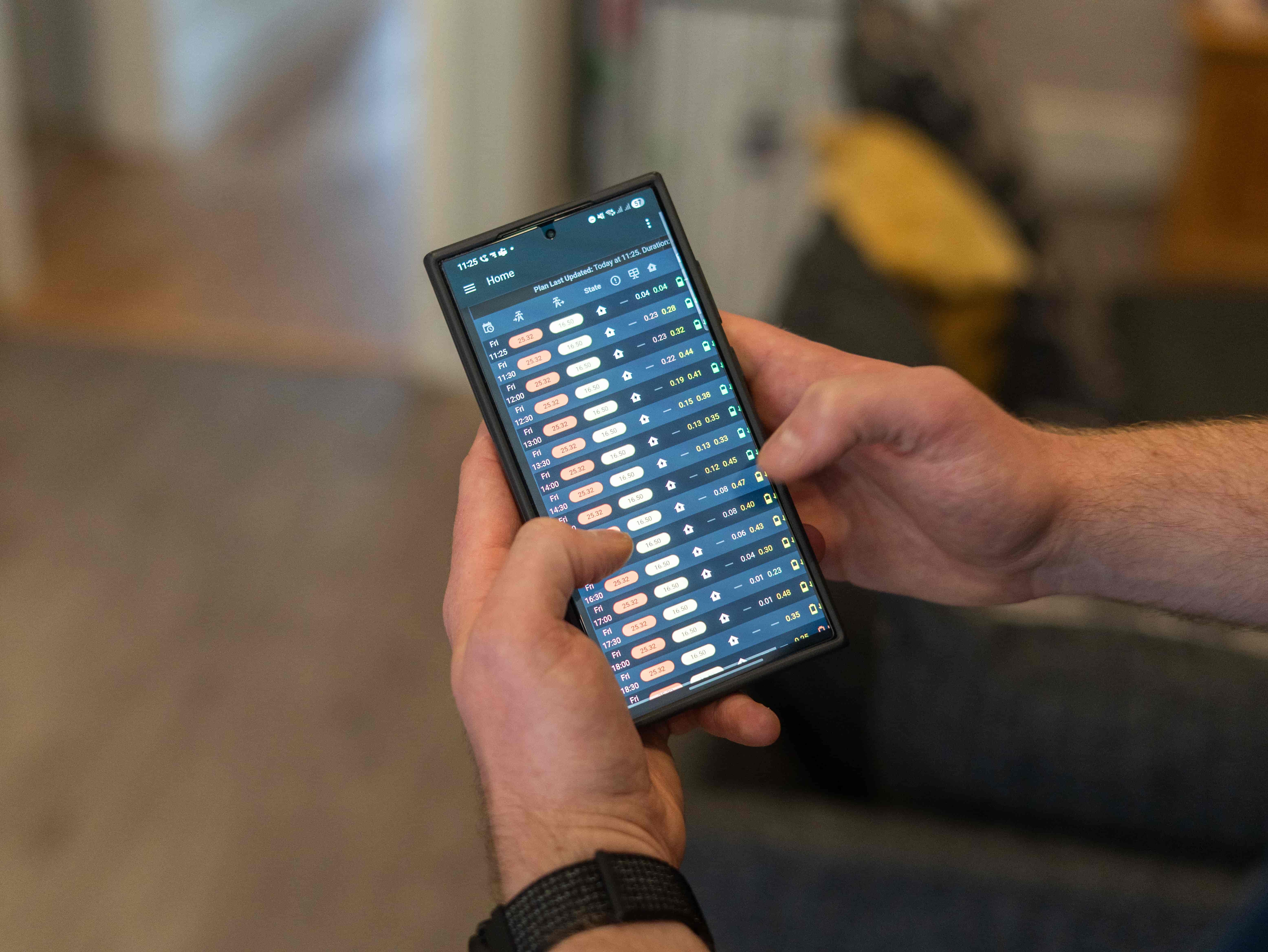 someone holding a smartphone showing energy consumption data on the screen