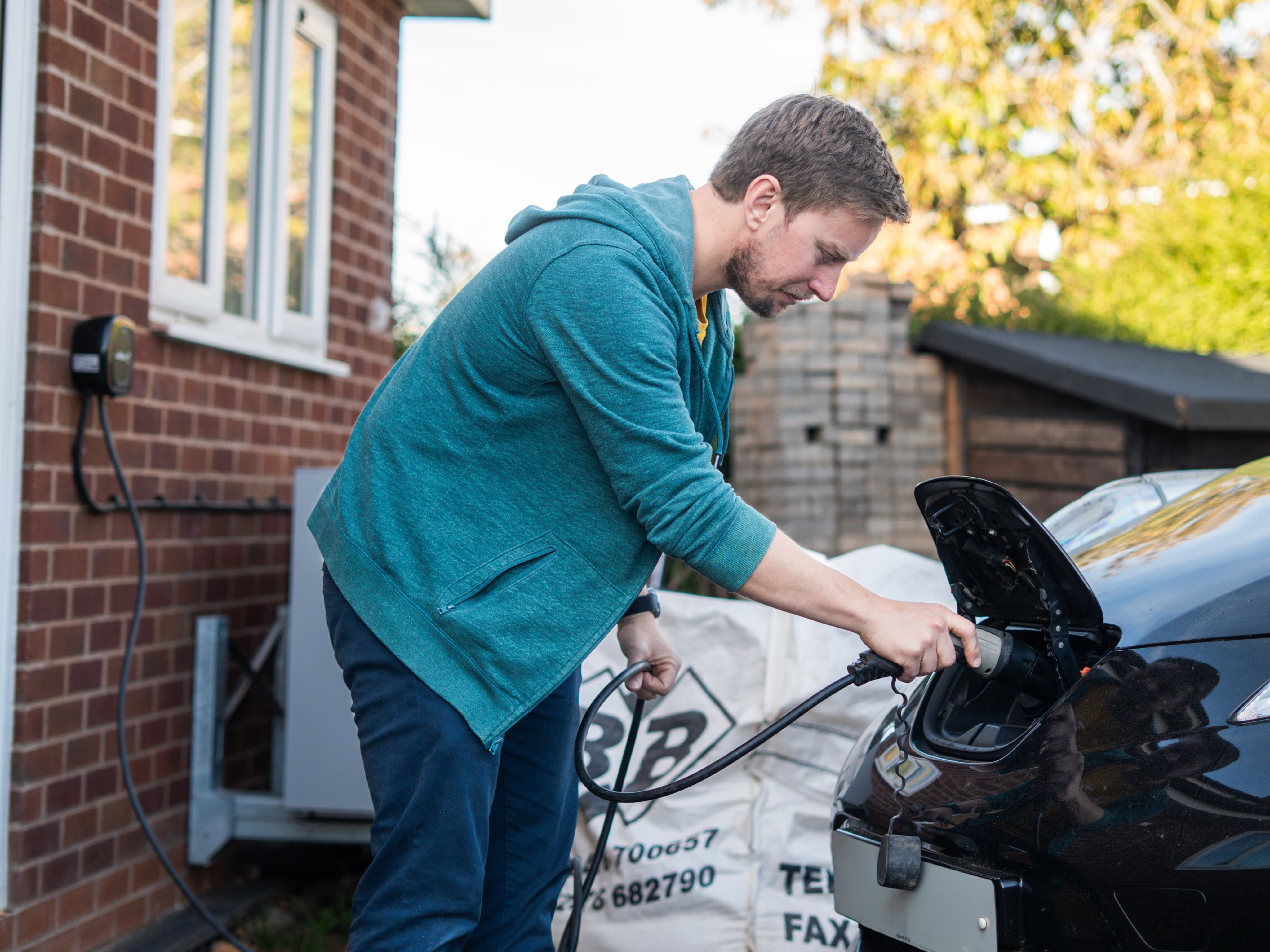 man charging ev
