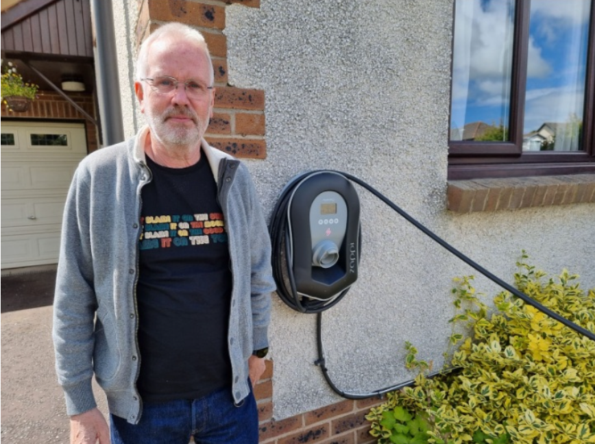 man standing infront of ev charger